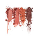 Smears of different shades of pink and red makeup on a white background