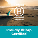 Surfboard on a beach with sunset, Certified B Corporation logo, and text 'Proudly BCorp Certified'.