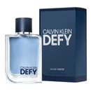 A bottle of Calvin Klein Defy Eau de Toilette with a navy blue label and cap, alongside its packaging box.