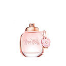 Pink perfume bottle with rose gold cap and decorative elements on a white background