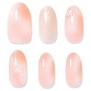 Six oval nail tips arranged in two rows on a white background, showing different nail art finishes: soft peach-to-pink gradient, glittery pale pink, and peach glitter with white bow-like line details.