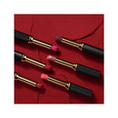 Set of lipsticks with black and gold cases on a red textured background