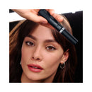 Woman holding a black beauty product labeled 'Telescopic Lift' above her face.