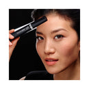 Woman holding a cosmetic product labeled 'Telescopic Lift' against a black background