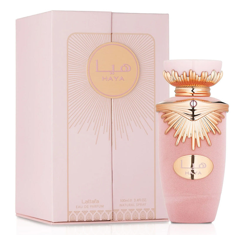 Pink perfume bottle with gold accents and matching packaging on a white background