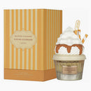 Perfume bottle with whipped cream and chocolate syrup next to a striped box labeled 'Give Me Gourmand'.