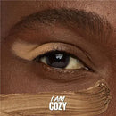 Close-up of a brown eye with 'I AM COZY' text overlay