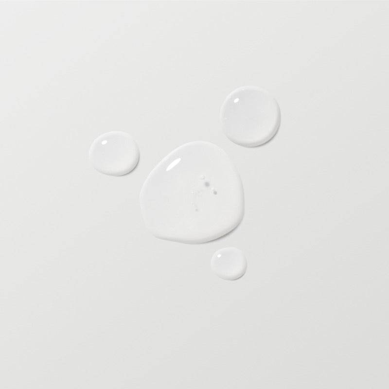 Close-up of white paint droplets on a light gray background