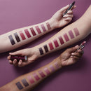 Lipstick swatches on arms with three lipsticks held above, against a purple background
