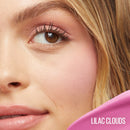 Close-up of a woman's face with 'Lilac Clouds' product in the corner