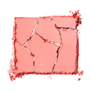 Pink makeup swatch with crumbled texture on a white background