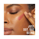 Close-up of a person applying makeup with text 'JUST DOT, DOT BLEND'.