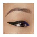 Close-up of an eye with a black eyeliner and blue wing, on a beige background