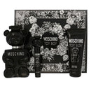 Moschino Toy Boy fragrance gift set featuring a black teddy bear-shaped perfume bottle, a small matching spray bottle, a black tube of perfumed body gel, and a floral-patterned presentation box.