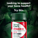 Nature's Own Vitamin K2 supplement bottle with green leaves in the background