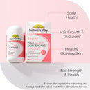 Nature's Way Beauty Hair Scalp Skin & Nails supplement set on a soft pink background, featuring a white bottle and a white-and-pink box with callout lines pointing to key benefits: scalp health, hair growth and thickness, healthy glowing skin, and nail strength and health.