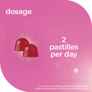 Pink packaging with two red pastilles and dosage information on a pink background