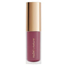 Lipstick with gold cap and 'nude by nature' branding on a white background