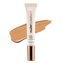 Nude by Nature Perfecting Concealer in a white squeeze tube with a metallic rose gold cap, shown in front of a beige cream makeup swatch on a white background.