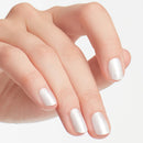 Close-up of a hand with white nail polish on a light background