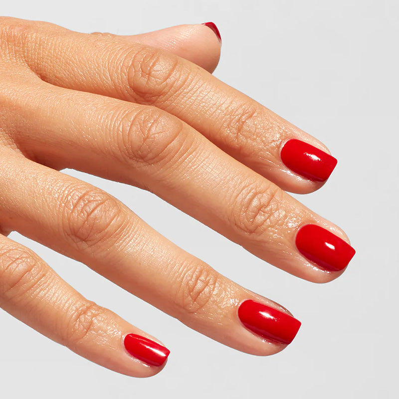 Hand with red nail polish on a light gray background