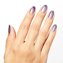 Hand with purple nail polish on a white background