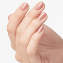 Close-up of a hand with pink nail polish on a light background