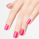 Hand with bright pink nail polish on a light background