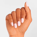Hand with light pink nail polish on a plain background