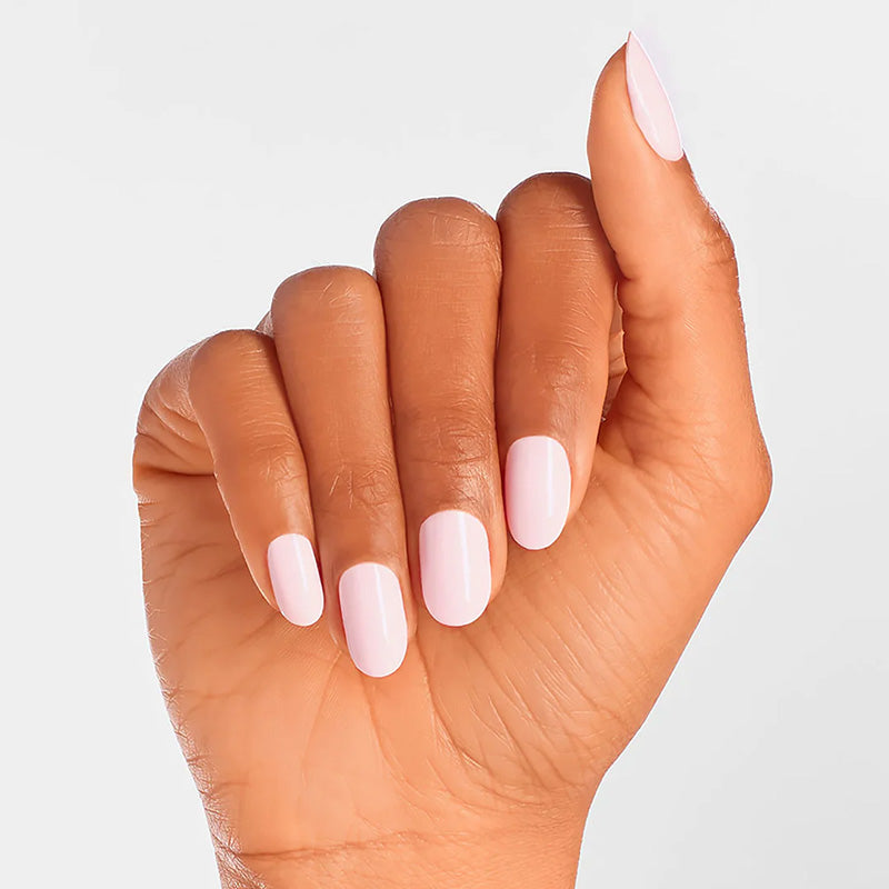 Hand with light pink nail polish on a plain background
