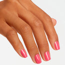 Close-up of a hand with pink nail polish on a light gray background