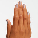 Hand with light purple nail polish on a plain background