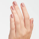 Hand with neatly manicured nails on a light gray background