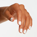 Hand with white nail polish on a light background