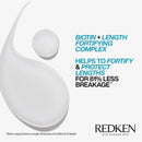 Redken shampoo bottle with text about biotin and length fortifying complex on a white background
