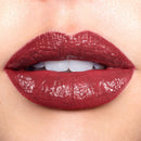 Close-up of a person wearing a glossy red lipstick.