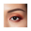 Close-up of a woman's eye with smoky eye makeup on a white background