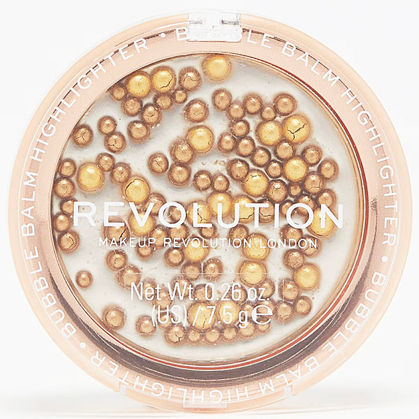 Revolution makeup balm highlighter with gold and beige beads on a white background