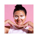 Woman wearing eye patches with a pink background