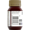 Back view of a dark amber plastic supplement bottle with a ribbed olive-brown cap and a white label showing product information, barcode, QR code, and certification logos.