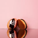 Makeup brushes with a brand logo on a pink background