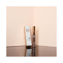 Brow product with packaging on a reflective surface and beige background