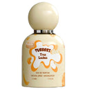 A 50ml bottle of Tubbees Tres Leches Eau de Parfum with a cream-colored spherical cap and a matching cream bottle decorated with orange and brown chocolate splash graphics.
