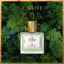 Perfume bottle with 'Earth Zodiac Elements' branding against a forest background